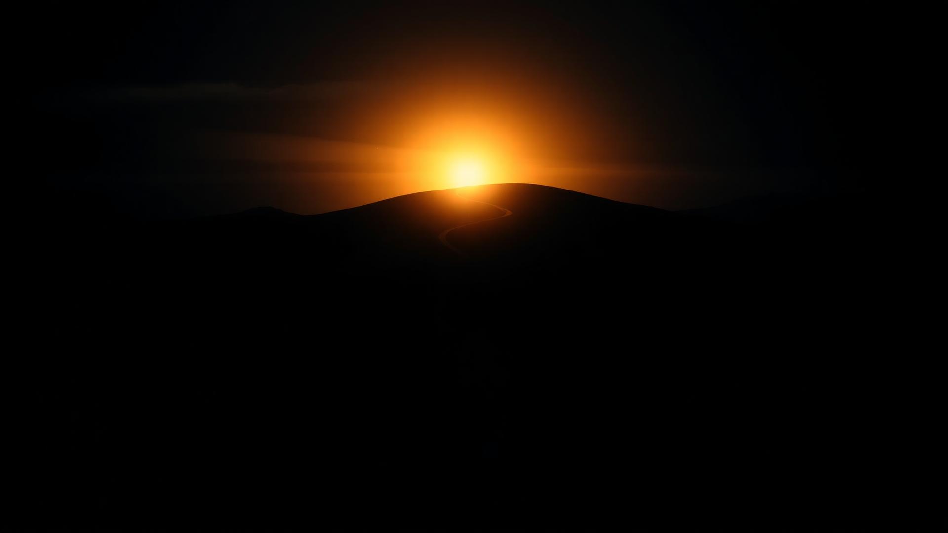 Dawn breaking over a dark landscape representing transformation